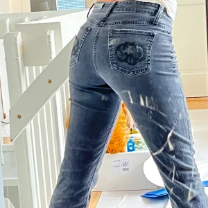  Lowrise Cambio-jeans med bling på bakfickorna - Säljer dessa gråa, straightfit Cambio-jeans då de är lite korta på mig (167cm). De är lowrise och har svarta, små rhinestones i patches i y2k mönster på bakfickorna. De är i fint skick, inte trasiga eller några okända fläckar! Köparen står för frakten ☺️☺️