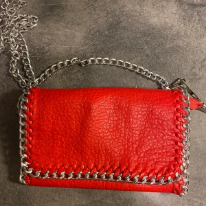 Röd axelremsväska  - En super fin röd Stella McCartney likande axelremsväska, använd några gånger men är i bra skicka! Inga tydliga markeringar