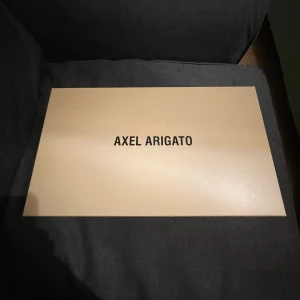 Axel Arigato skor  - Hej jag säljer mina arigato skor med snören.  Svart/vita. Storlek 42 men passar även 43.  Använt de i endast en månad.  Box ingår.  Pris kan diskuteras   ( För flera  bilder kom dm)