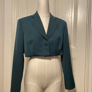 Croppad kavaj  - Grön Croppad kavaj. Omsydd av mig. Inga synliga tecken på användning! Storlek: S