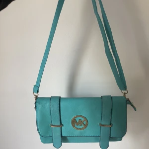 Blå handväska - Blå medelstor handväska, mycket rymlig med justerbart band vilket gör att du både kan använde den som en som en kort axelväska eller en väska med långt band som går snett över kroppen