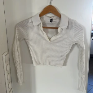 Vit tröja - En vit långärmad ribbad tröja från Hm med krage och v ringad. Lite kortare i modellen.