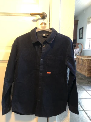 Manchester overshirt - Stilren Manchester overshirt från hunmel, perfekt till sommaren.  Färg: marinblå  Skick: 8/10 Nypris: 600 Mitt pris: 150 kr  Storlek: 164  Funkar perfekt med skjorta eller t-shirt under. 
