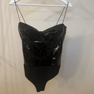 Body i lack - Sååå snygg och sexig body i lack från Nelly i storlek M. Endast använd två gånger så i fint skick!