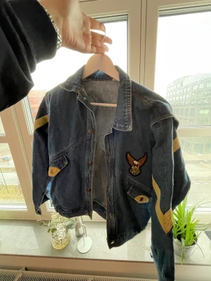 Jeansjacka  - Retro jeansjacka inköpt på Beyond Retro för 500 SEK för ett par år sedan. Coola detaljer med stor ryggtavla. Sparsamt använd.   Oversize passform, brukar ha M och denna sitter löst på mig!   💌Kan mötas upp i centrala Malmö eller skicka mot fraktkostnad!