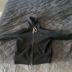 Ralph Lauren Hoodie - En jättefin och skön hoodie från Ralph Lauren perfekt nu till kallare väder. Ett litet hål vid ärmarna som knappt syns men skicka iväg ett medelande så löser vi pris