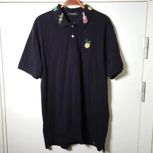 Scotch & Soda-pikè - En lång svart piké med broderade figurer runt kragen och på bröstet. Ingen storleksmärkning men tippar på XL-XXL (funkar som typ en kort klänning på mig som är 164cm)🌿