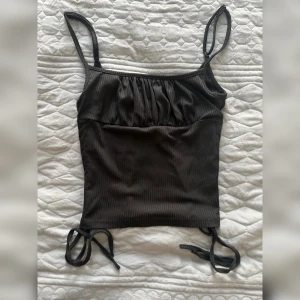 Fin topp ribbad  - Fin topp som kan bäras till fest eller som en basic. Ribbad på sidorna med snören. Storlek S. Kan fraktas för 25 kr eller mötas upp i Stockholm/Norrköping. 