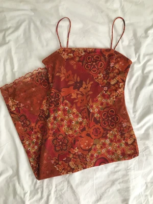 Vintage klänning - Vintageklänning med otroligt mönstrat mesh över en orange underklänning! Det finns en liten reva i tyget som inte är speciellt märkbar, skriv om en mer delajerad bild önskas💌