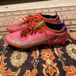 Nike Mercurial Vapor 14 Elite FG - Jättefin Nike Mercurial Vapor 14 Elite i rött.  De har använts lite och har några märken skick 6,5/10.  Don är jette lätta och bekväma. Nypris 1500. Meddela mig om priset :)