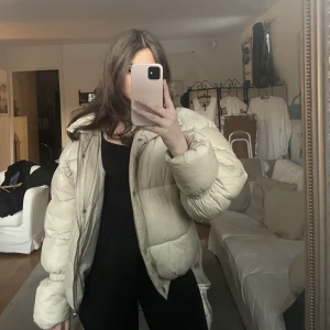 Pufferjacka - Jacka från nakd. Inte tvättat, har därför en sminkfläck vid kragen. Råkade klippa när jag öppnade paketet så syns lite vid axeln men inget som man lägger märke till vid användning. I övrigt gott skick 