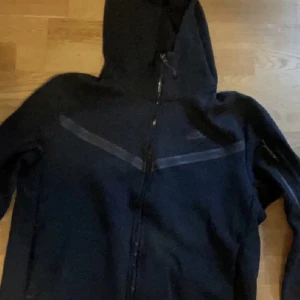 Svart Nike tech  - Hej, säljer min Nike tech som jag köpte i höstas för att den blev mindre än mig men annars är den i fint skick.Mer bilder kommer om ni kontaktar mig!!!!  
