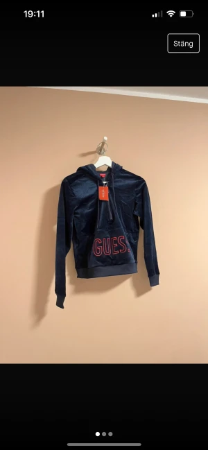 GUESS - Helt ny Guess hoodie i sammet med prislappen kvar på! Nypris 469 kr! Marinblå med röda detaljer