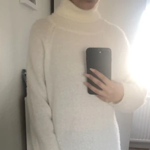 Vit fluffig klänning  - Lång, vit klänning i fluffigt stickat material, med turtleneck.  Storlek: 34 Märke: Missguided  Använd 1 gång, nyskick. 