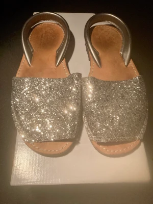 Snygga sandaler i silver Stl 36 - Silvriga sandaler i stl 36 fr Spanien med lädersula inuti, fint skick, använda fåtal ggr. 