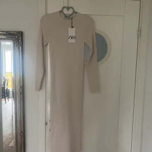 Längre klänning - Längre beige/vit klänning som är helt oanvänd, perfekt till hösten. Frakt tillkommer.