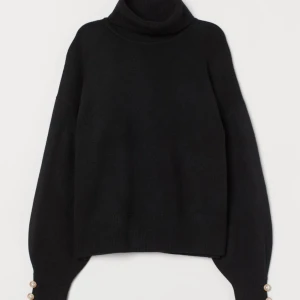 Stickad tröja  - Stickad svart tröja med polokrage och pärlor vid armleden. Andvänd.