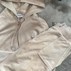 Juicy Couture  - Juicy Couture set i beige. Tröjan är i M och är använd fåtal gånger. Byxorna är i S och är helt nya. Båda delarna av settet är i nyskick! Passar någon som normalt har storlek S. Nypris för hela settet är 2300 kr.