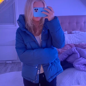 blå dunjacka - blå dunjacka ifrån strandivarius, köpt förra året men kom inte till mycket användning, knapparna på båda fickorna är trasiga men går att fixa med nya knappar 🙌🏼 (frakt tillkommer på 66kr)