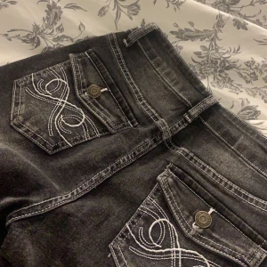 Jeans - Säljer mina svarta jeans med mönster på fickorna. Har aldrig används så är i väldigt bra skick. Passar er som är lite kortare runt 155-160( är det många som är intresserade blir det budgivning💞)