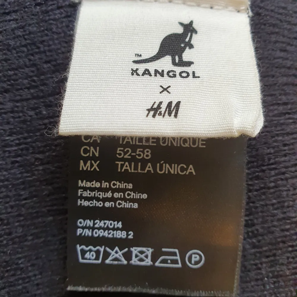 Kangol for H&M mössa i svart med vit tofs. Storlek 52-58. . Accessoarer.