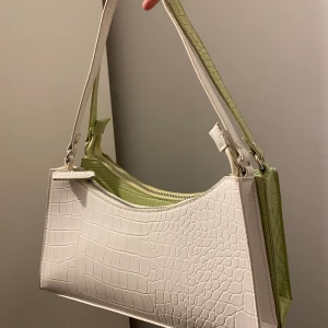Väska - Vit väska i krokodilmönster. Knappt använd och inga tecken på användning! Har även en likadan i grön till salu😊