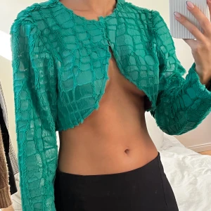 Blågrön liten kavaj/topp - Fantastiskt fin blågrön färg, går att ha som lite  kavaj med topp under eller som topp om man binder ihop med en liten säkerhetsnål. 