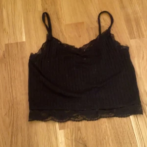 Svart linne med volang  - Det är ett svart linne med volang, använd