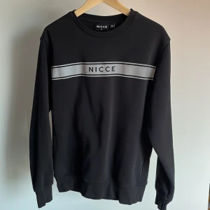 NICCE sweatshirt - strlk M - Svart sweatshirt med coolt reflekterande tryck. Normal passform. Inga flaws utom några få sprickor i trycket.