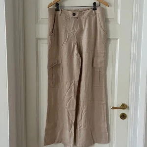 Lågmidjade linnebyxor - Oanvända linnebyxor från Urban Outfitters med låg/mid-waist. Beställde flera i olika färger/storlekar men dessa var tyvärr lite för stora. Använder de andra flitigt och det är mina absoluta favoritbyxor. Snygg passform med cargo-fickor. Jag är 1,70 lång.