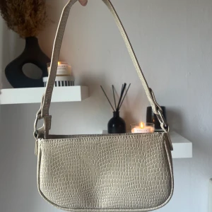 Väska - Detta är en fin väska från asos, använd en gång (därför bra skick). Den kostar 249kr ordinarie. Färgen är som på första och sista bilden. Andra bilden är mer för att visa materialet men ger ej en rättvis bild av färgen. 