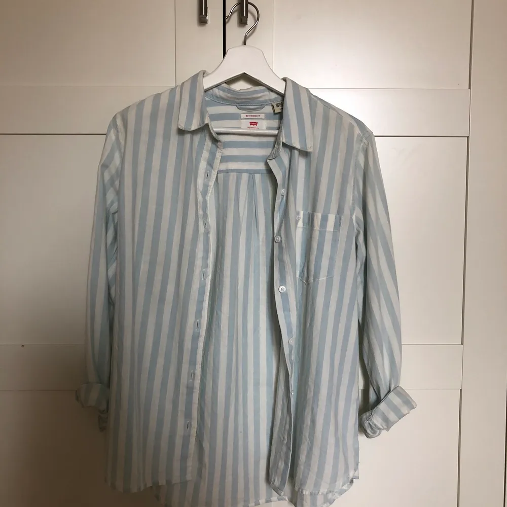 Jag säljer en likande skjorta som på 1a bilden ovan. En skjorta från levis i med blåa och vita ränder perfekt till sommaren är aldrig använd utan endast provad, och i boyfriend fit. Skjortor.