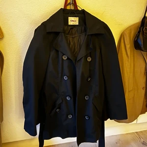 Svart trenchcoat - Svart tenchcoat i strl L men är mer som en M. Köpare står för frakt.