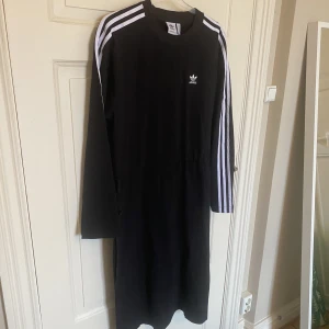 Jerseyklänning från Adidas  - Säljer denna ursnygga klänningen från Adidas. Helt ny med prislapp kvar. Nypris 799kr. Köpt på Zalando. Storlek 34, men passar större bättre. Skulle säga att den passar som M. Snörning på sidan för att dra åt midjan. 100% bomull. 