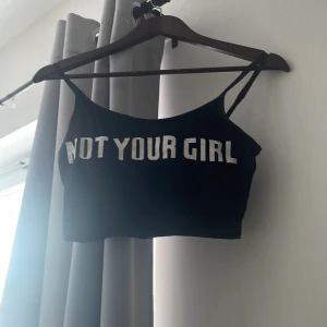 Linne med text - En svart topp med texten not your girl på, haft i många år men nästan aldrig andvänd, trasig på bandet på vänster arm men går lätt att fixa 