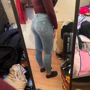 Ripped jeans - Blåa slitna jeans från Hollister. Storlek 26/26. Passar den som har storlek XS/S.