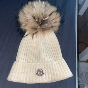 Moncler mössa med pälsboll - Jag säljer min moncler mössa då den inte kommer till användning. Den är äkta och pälsen med. Storlek L men passar även M. Pris kan diskuteras vid snabb affär. Kom privat för mer info☺️