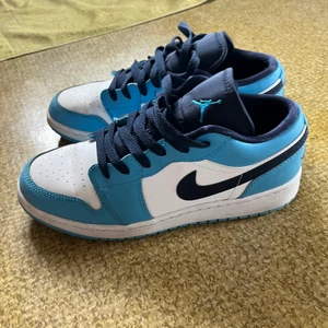 Air Jordan Low UNC 2021 (GS) - Air Jordan Low UNC 2021 (GS) knappt använda. Lite creasing fram på skorna annars som nya. Köparen står för eventuell frakt. 🌸