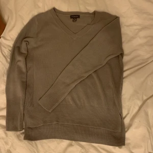 Mörkgrå tröja - V ringad Mörkgrå stickad tröja från primark med slits nertill. Bara använt typ 2 gånger.
