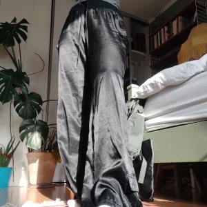 90s silkesbyxor i cargomodell - Superballa byxor från 90-talet med fickor på sidorna! Har satt in ett skosnöre i midjan (medföljer tyvärr inte), men funkar lika bra utan beroende på önskad passform! Kan användas både låg- och högmidjat. Fler bilder finns! 