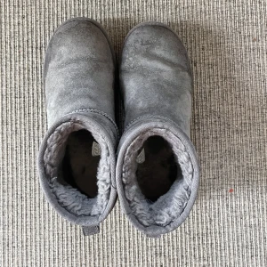 Gråa Uggs - Gråa Uggs i storlek 38. Dem har några vattenskador längst fram. Säljs för att dem är för små.