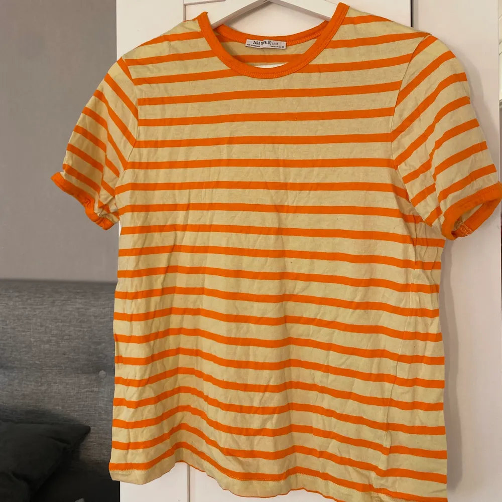 En jättefin orange/gul randig t-shirt från Zara i storlek S. Säljes för 50 kr+frakt. T-shirts.