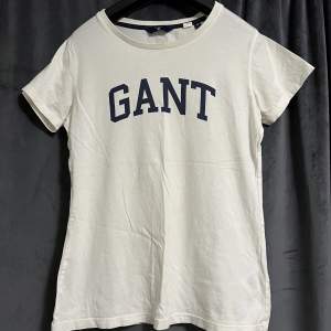 Vit Gant t-shirt med marinblå logga. Använd fåtal gånger. T-shirten är i bra och fint skick. Storlek XS. Pris kan diskuteras.  Köparen står för frakten. Betalning sker via Swish.