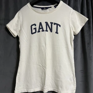 Gant T-shirt  - Vit Gant t-shirt med marinblå logga. Använd fåtal gånger. T-shirten är i bra och fint skick. Storlek XS. Pris kan diskuteras.  Köparen står för frakten. Betalning sker via Swish.