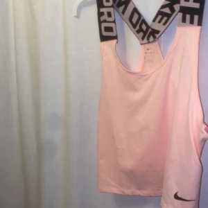 Träningslinne  - Ljusrosa träningslinne från Nike. Står Nike PRO på axelbanden 