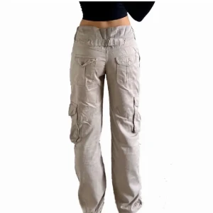 Cargo byxor - Ett par lågmidjade beiga cargo byxor köpta här på plick! Jag har lånat bilder🌟innerbenslängden 80cm, midjemåttet 79cm. Jag är 173cm lång och de sitter bra på mig i längden😁Köpta för 400kr men säljer för 150🤩Du står för frakten!
