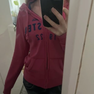 Hollister hoodie - Säljer denna fina rosa hollister zip up hoddien i strl S med blå text typ på! Inte kommit till användning då den köptes under fel årstid! Inga tydliga skador ❤️ skriv för mer information. 50+ frakt! Pris går att diskuteras 💕