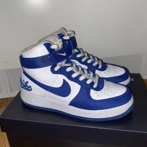 Nike Air Force 1 High EMB Dodgers - Nästintill nyskick, enda ”felet” är lite missfärgning på snörena från de blåa tyget men det går lätt att lösa med nya snören. Storlek 41, men dom är ganska smala så kanske inte funkar om man har bredare fötter. Hör av er om frågor eller fler bilder :)