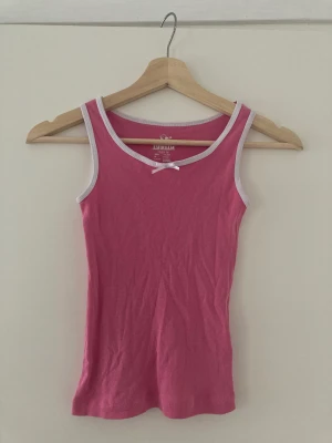 Rosa linne - Ett gulligt rosa linne med söt liten rosett. Köpt här på plick. Ganska liten storlek men med ett stretchigt material, skulle säga att linnet passar xxs-s. 