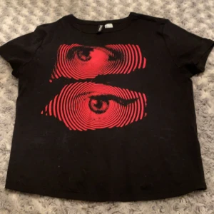 H&M DIVIDED svart tröja med röd print - Köpt på H&M, använt några gången men har ingen skada eller fläckar.   Storlek L men är ungefär en M